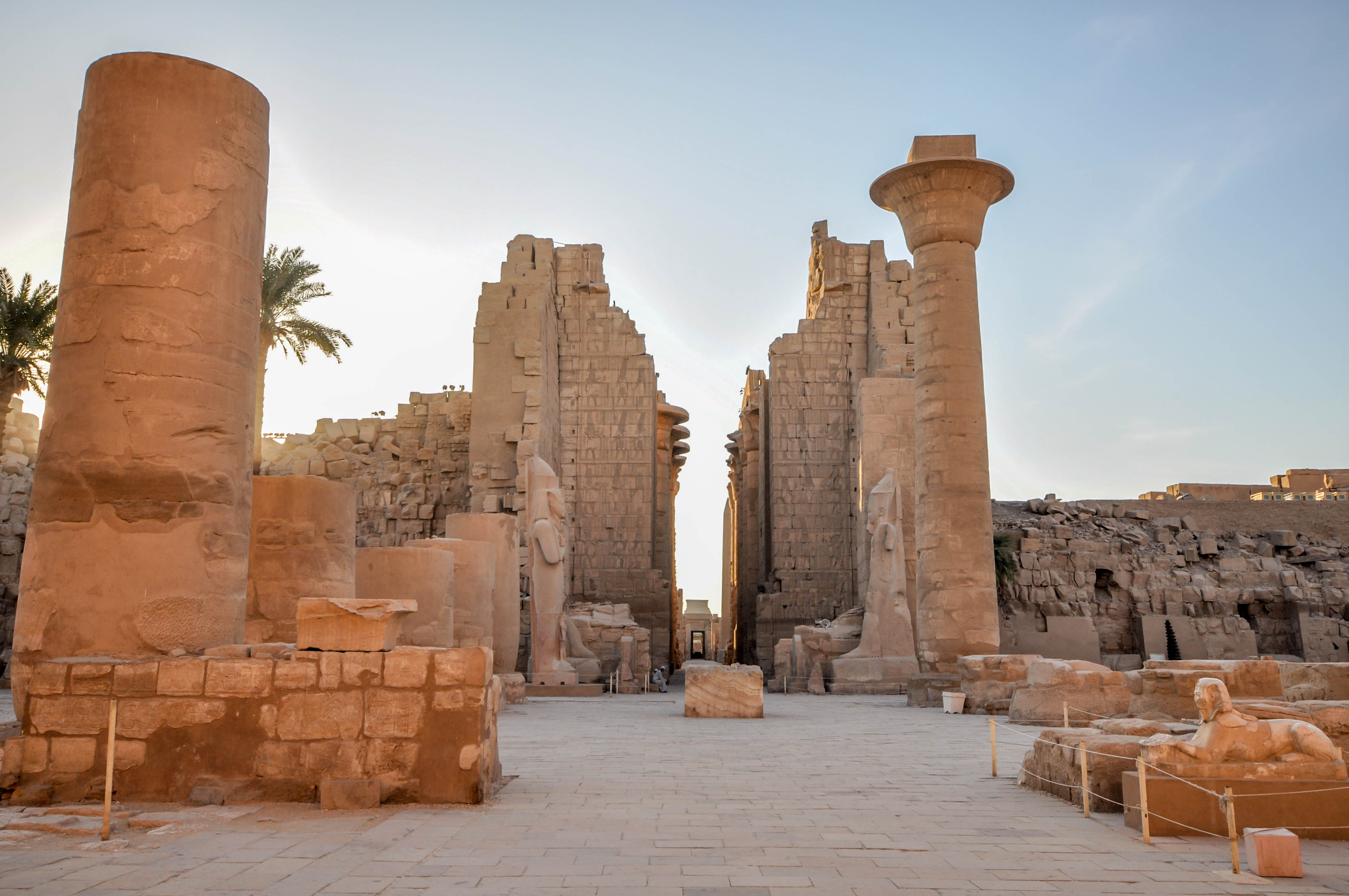 Tall stone column from Taharqa's kiosk at the Karnak Temple Complex in Egypt, with the temple's second pylon visible behind it